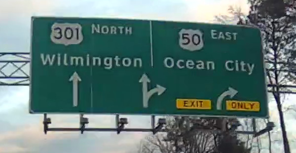 Image of signage at Queenstown in 2022, showing US-301 NB destination as Wilmington and US-50 EB destination as Ocean City